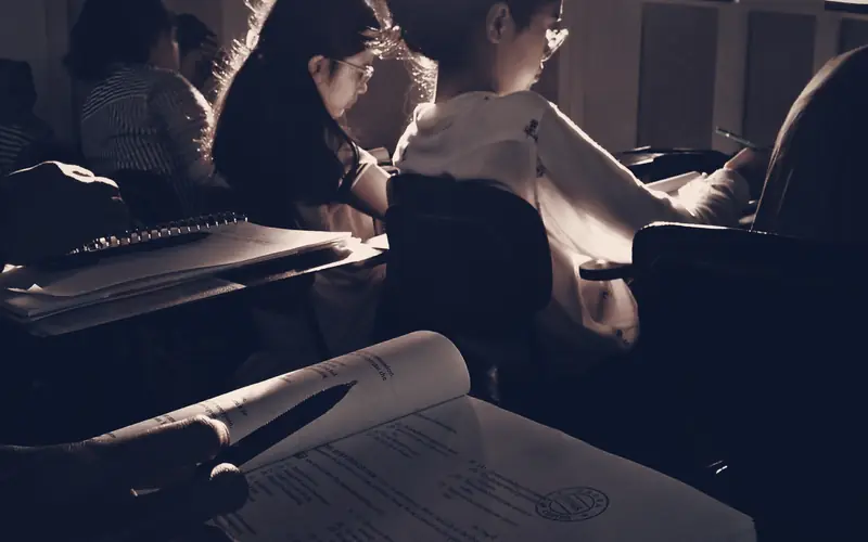 Students studying textbooks together in a classroom